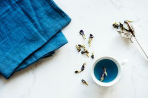 Decorative picture: some cloth, a tea cup and tea leaves - all held in blue